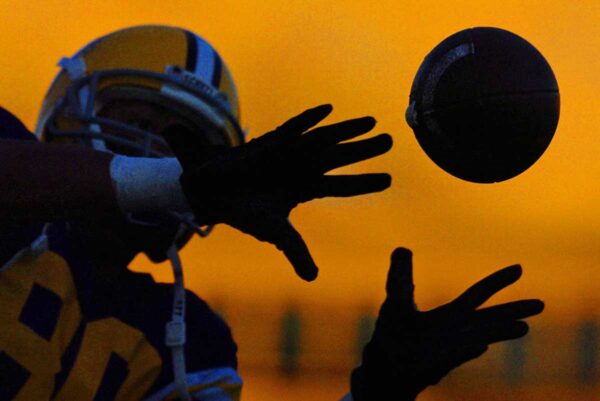 silhouetted football player catches a pass