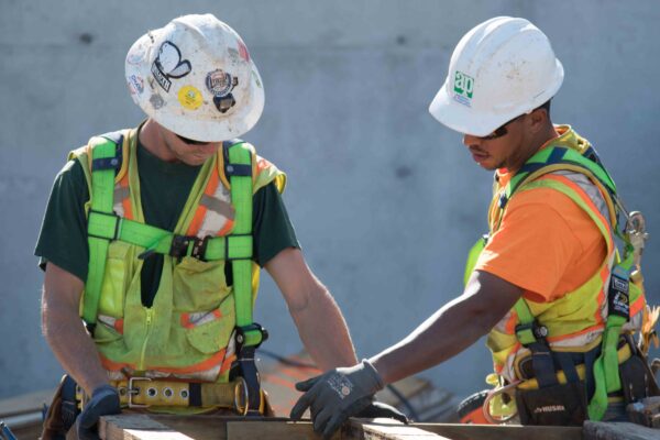 Union carpenters review blueprint on construction site