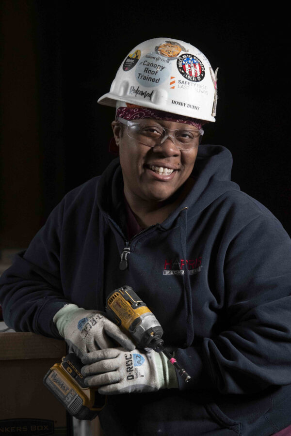 Black woman sheet metal worker holding Dewalt drill