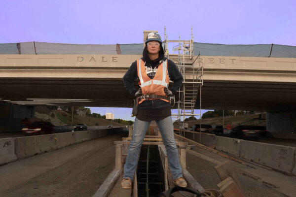 Woman iron worker standing at bridge construction site