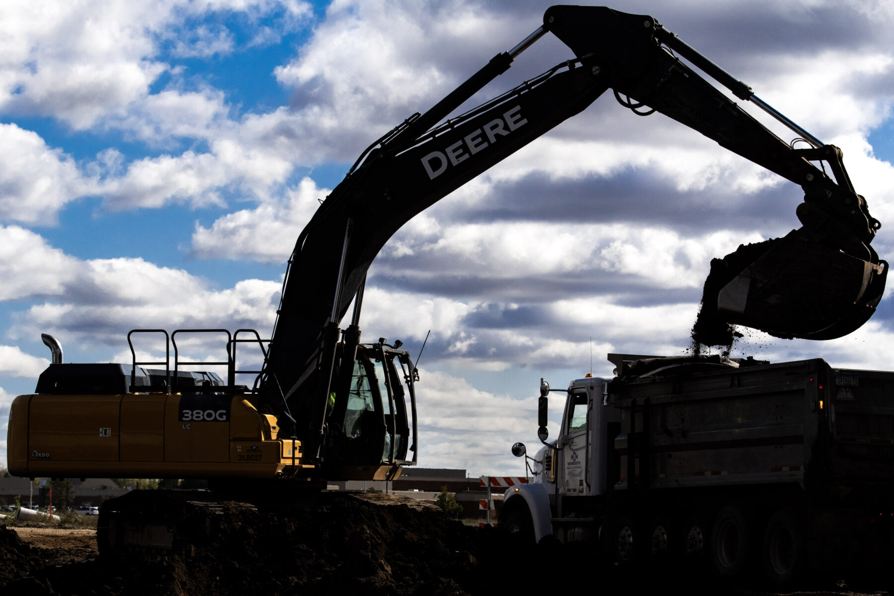 backhoe loading dirt on highway construction site