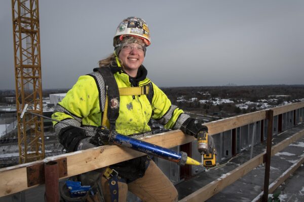 Female union plumber on roof of construction site